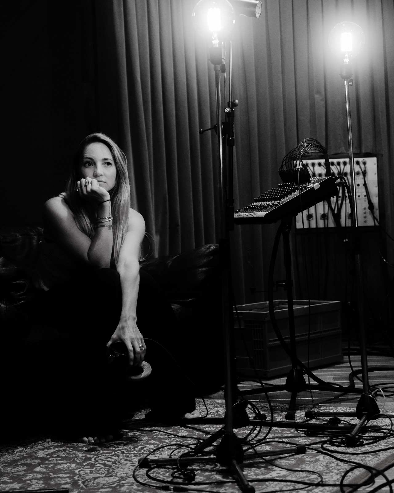 Co sitzend im Studio zwischen Lampen